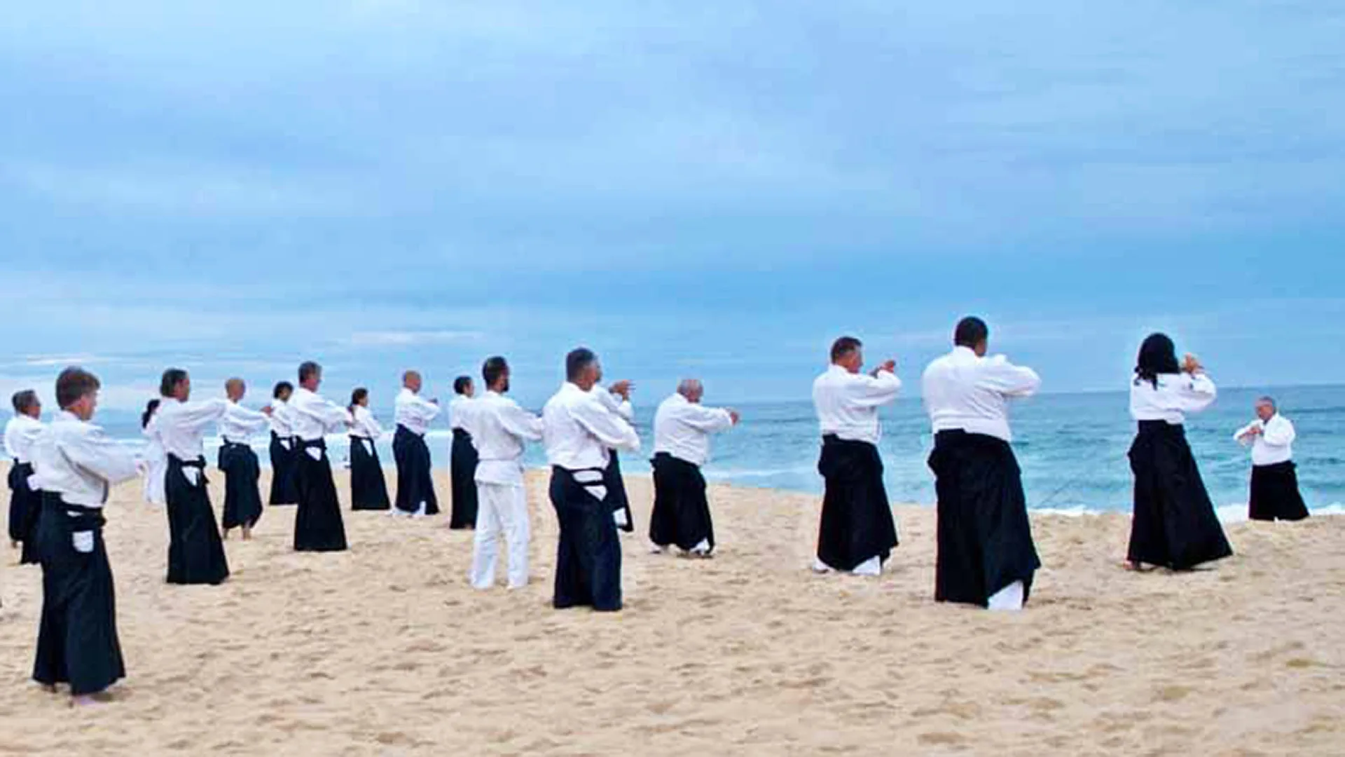 Préparation face à l'océan pendant un stage d'aïkido traditionnel favorisant calme, respiration et présence
