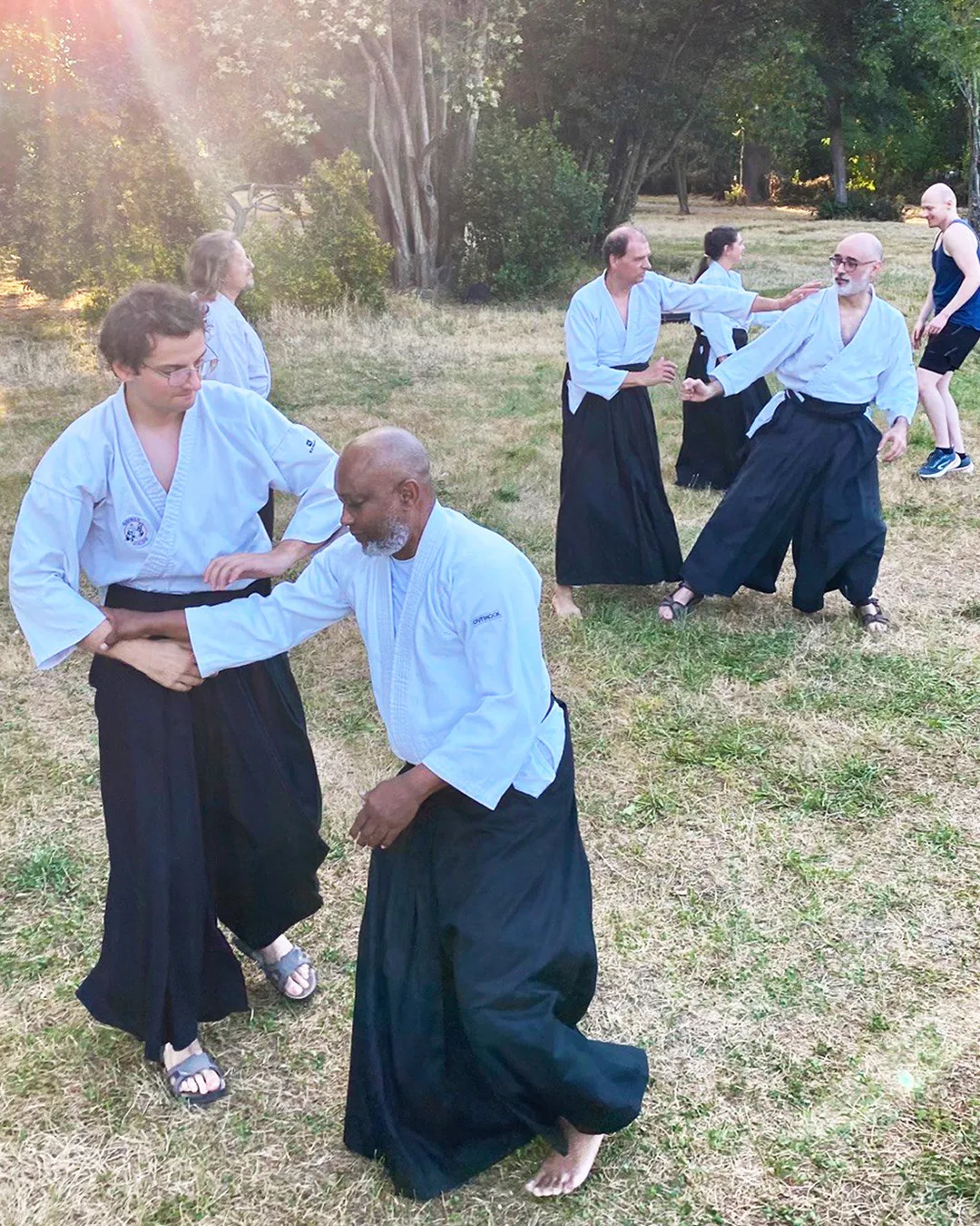 Pratiquants d'aïkido traditionnel partageant un travail collectif dans une ambiance conviviale et bienveillante.