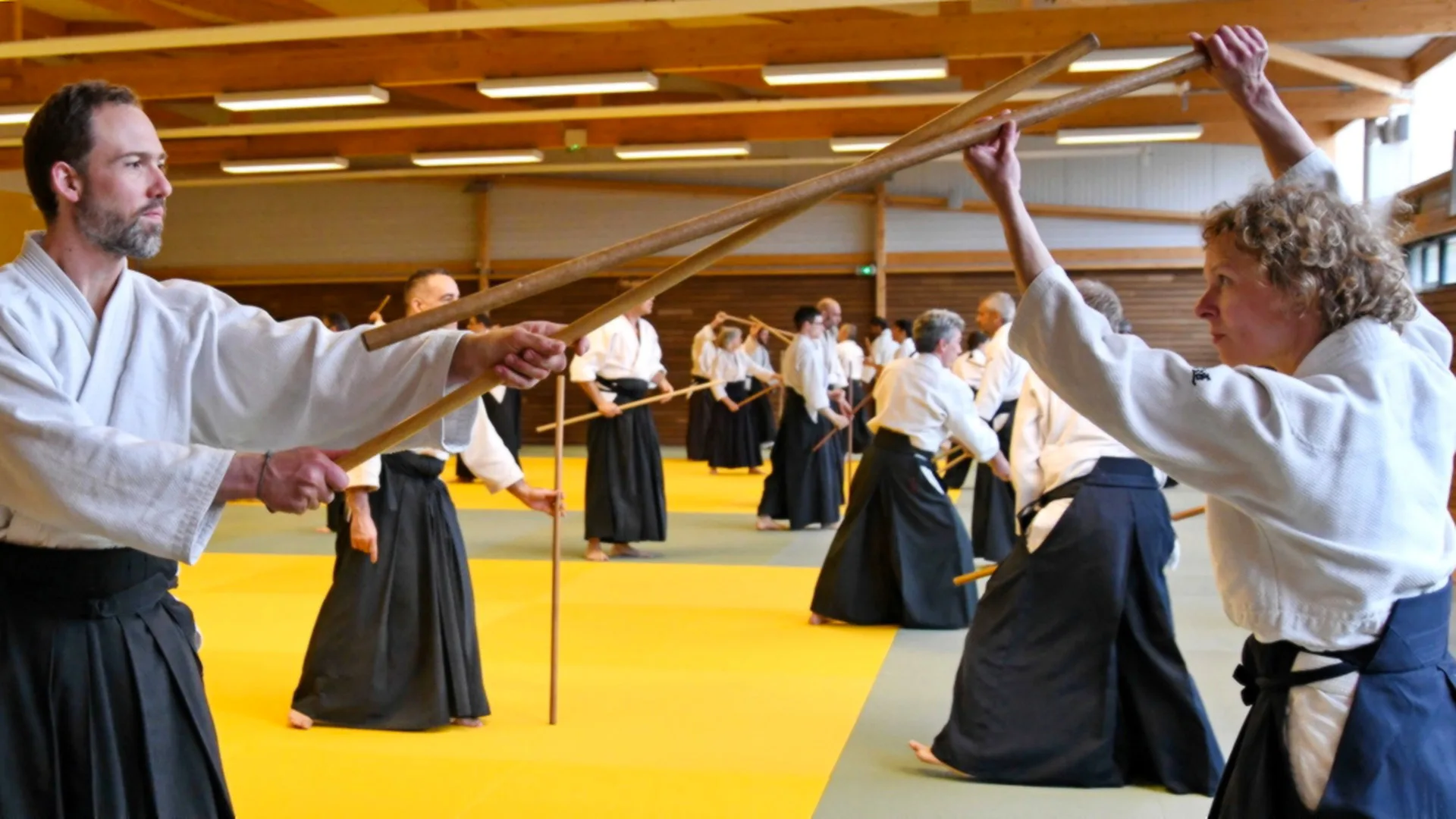 Pratique du jo lors d'un stage d'aïkido traditionnel développant précision, mobilité et coordination.