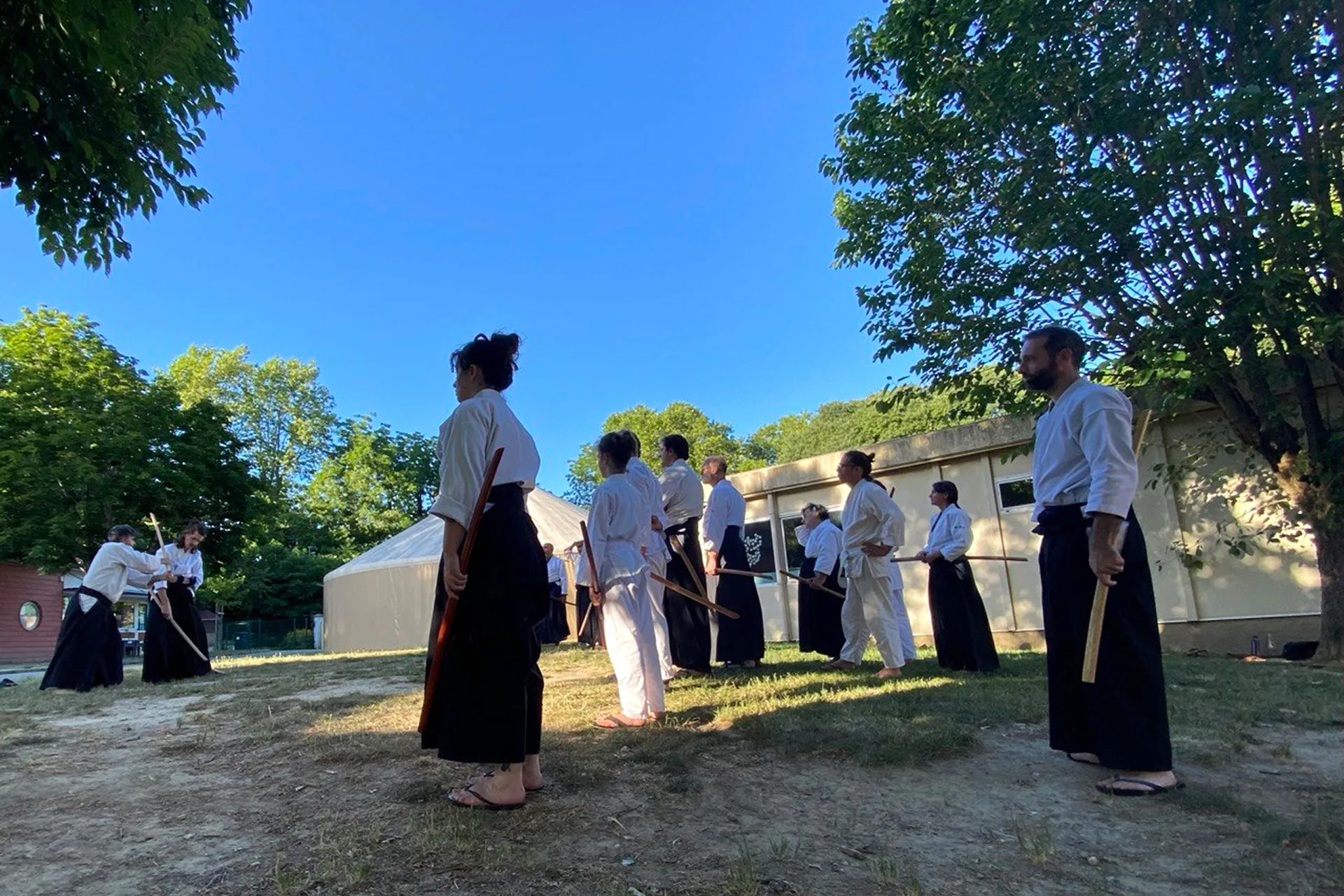 Cours d'aïkido traditionnel en extérieur à Toulouse, pratique des armes dans un esprit de transmission et de coopération.
